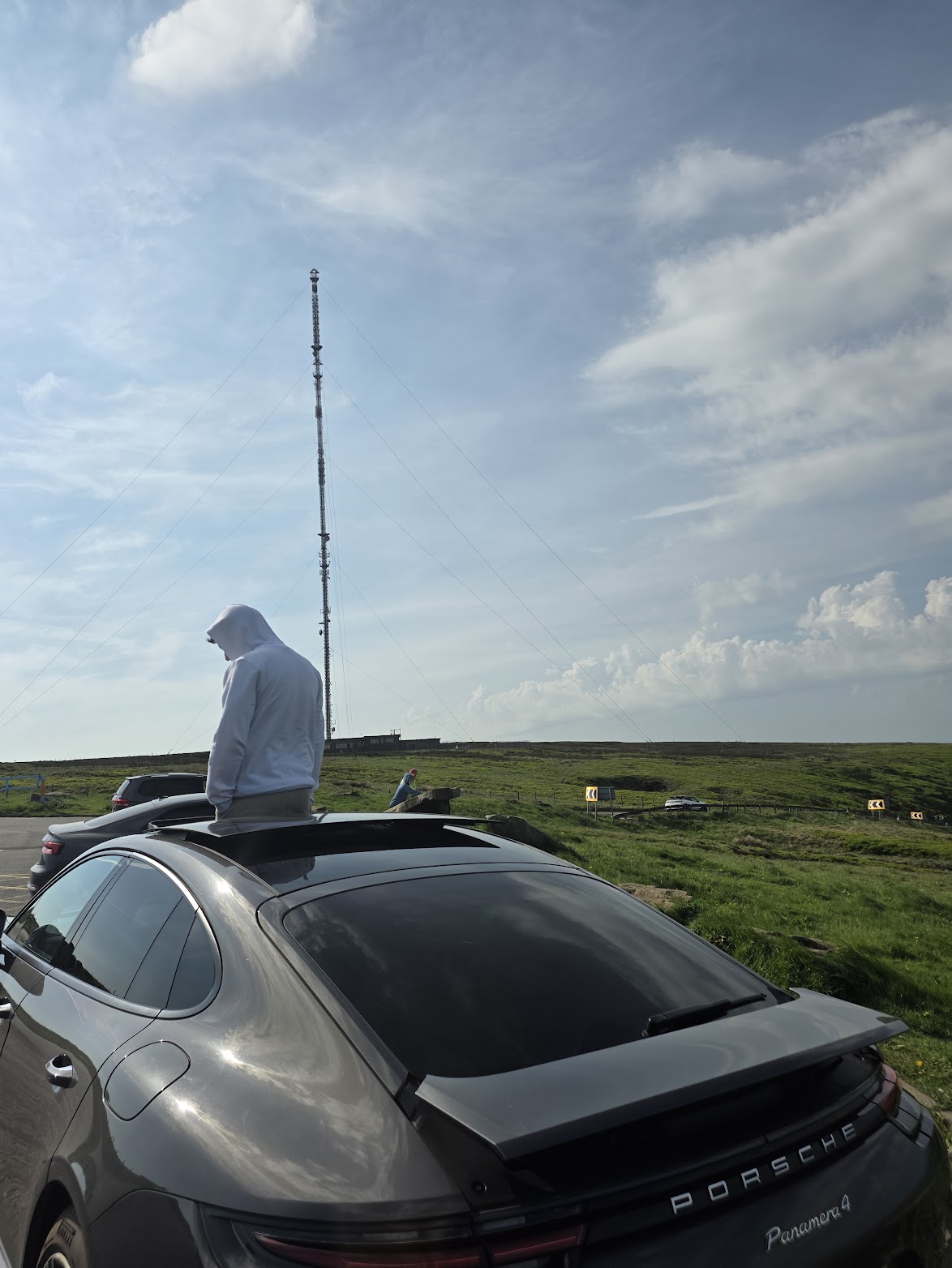 Mansukh taking action beside a Porsche in the countryside