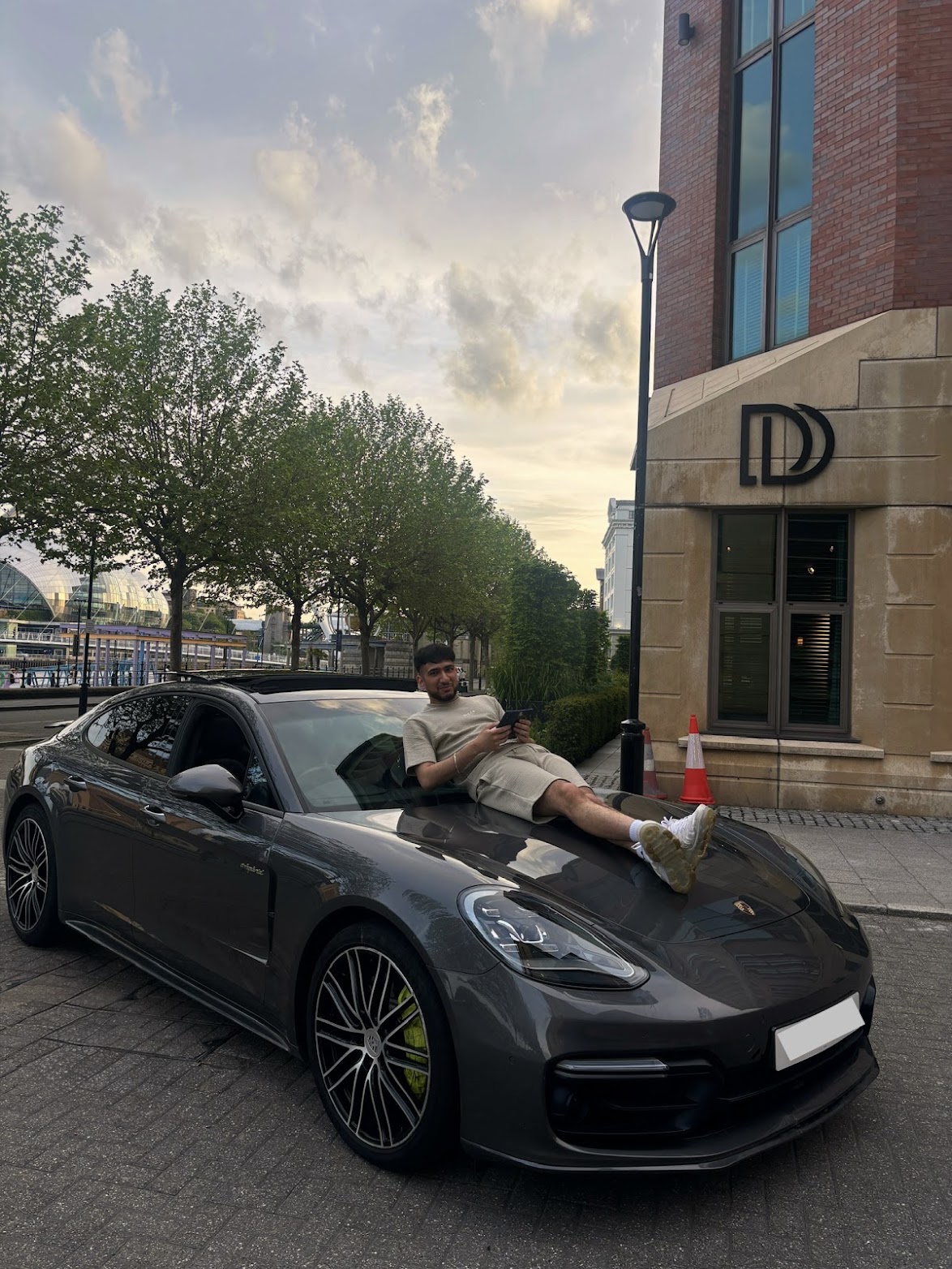 Mansukh reviewing his business beside a Porsche