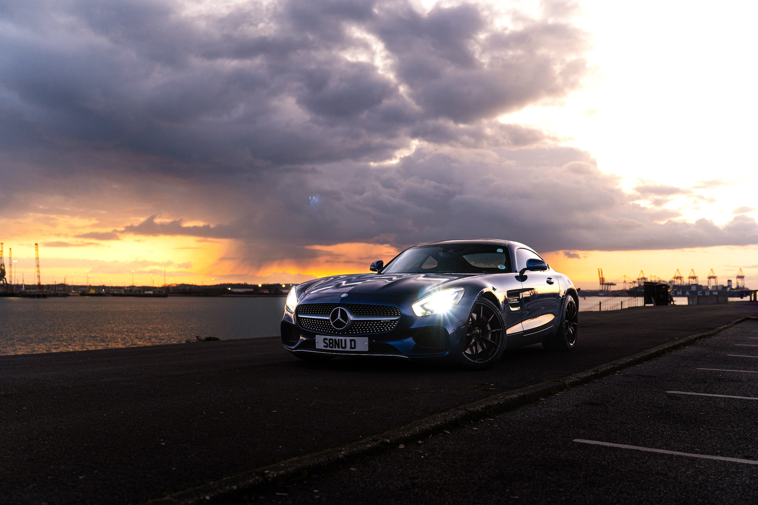 A blue Mercedes photographed at sunset